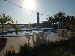 a table and chairs in front of a swimming pool at Pacha beach club in Barra de Tuxpan