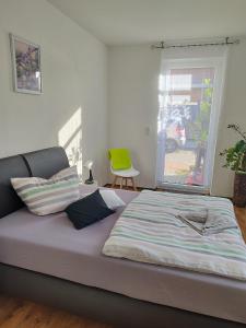 a large bed in a room with a green chair at Altes Forsthaus Zwenkau in Zwenkau