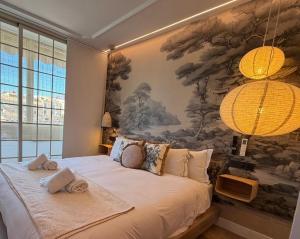 a bedroom with a bed with a painting on the wall at The Suite Collection in Fuengirola