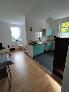 a large kitchen with blue cabinets and a table at Altes Forsthaus Zwenkau in Zwenkau