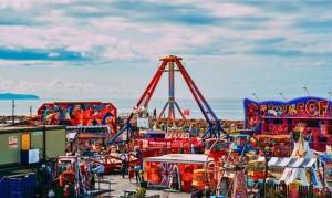 an amusement park with a roller coaster and rides at Ty Mawr Summerbreeze in Kinmel Bay