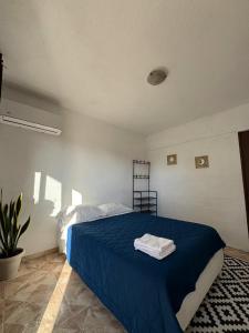 a bedroom with a bed with a blue blanket at Pacha beach club in Barra de Tuxpan +5 photos