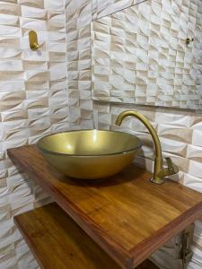 a bathroom with a green bowl sink on a wooden counter at Jardim Florestal Italy-Casa Jacarandá in Itaquatiara