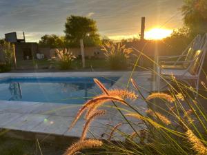 a swimming pool with a chair and the sunset at La Bodeguita in Trinidad