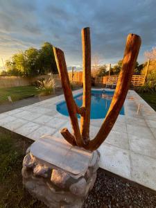 a statue of a wooden oar in front of a pool at La Bodeguita in Trinidad +5 photos