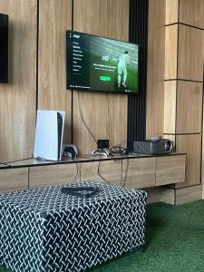 a flat screen tv hanging on a wall with a table at Montevar Hotel in Benin City +1 photo