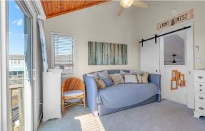a bedroom with a blue couch and a window at Isle be sea'n you in Rodanthe