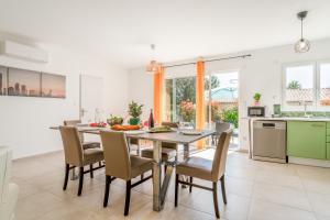 a kitchen and dining room with a wooden table and chairs at Villa Santa - Piscine - Wifi - Proche Ventoux - idéal Cyclistes in Mormoiron