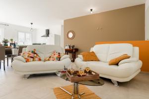a living room with two white couches and a table at Villa Santa - Piscine - Wifi - Proche Ventoux - idéal Cyclistes in Mormoiron