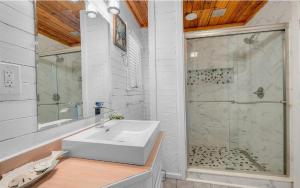 a white bathroom with a sink and a shower at Isle be sea'n you in Rodanthe +21 photos
