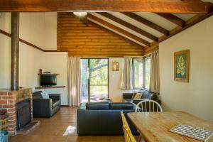 a living room with a couch and a table at Wyadup Brook Cottages in Yallingup