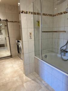 a bathroom with a shower and a washing machine at Design-Apartment am Wildbach mit Bergblick & direktem Zugang zur Natur in Fischbachau +19 photos