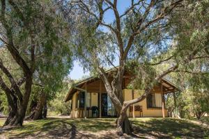 a house with trees in front of it at Wyadup Brook Cottages in Yallingup