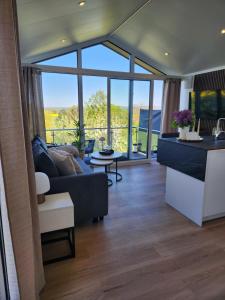 a living room with a couch and a large window at Bei Herze - Tiny Wohnen im Odenwald in Bad König