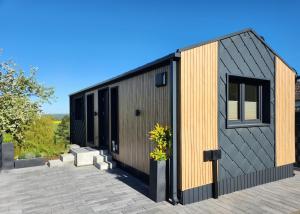 a modern house with a black and wood exterior at Bei Herze - Tiny Wohnen im Odenwald in Bad König