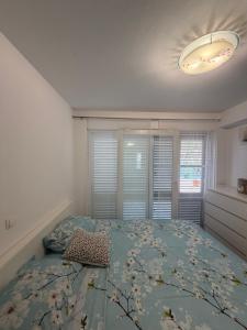 ein Schlafzimmer mit einem Bett mit einer geblümten Tagesdecke in der Unterkunft Apartman Teo in Blace