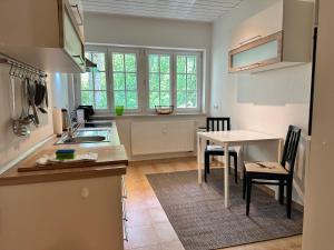 a kitchen with a table and a dining room at Design-Apartment am Wildbach mit Bergblick & direktem Zugang zur Natur in Fischbachau