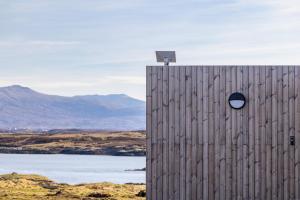 a wooden building with a window on the side of it at Bothan By The Bay, Benbecula in Grimsay