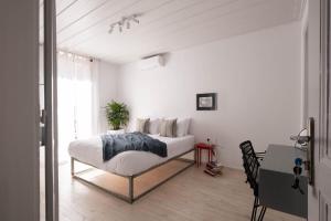 ein weißes Schlafzimmer mit Bett und Schreibtisch in der Unterkunft Araldo in Chania