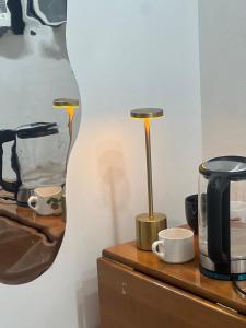 a desk with a lamp and a coffee pot on it at OM Center Apartments Tirana in Tirana