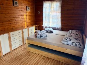 a bedroom with a bunk bed and a window at Chatičky pod Kamínkem Doksy in Doksy
