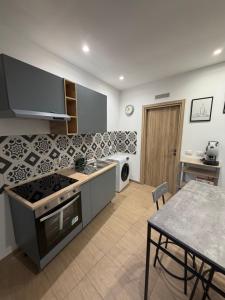 a kitchen with a stove and a table in it at Casetta Villabate in Villabate +10 photos