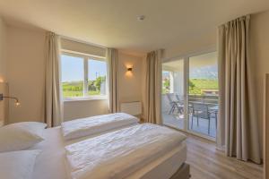 ein Hotelzimmer mit zwei Betten und Balkon in der Unterkunft Hotel Cornelian Suites & Rooms in Appiano sulla Strada del Vino + 205 Fotos