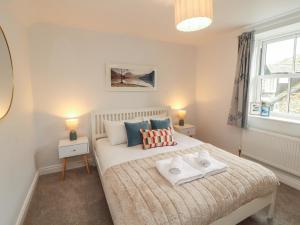 a bedroom with a bed with two towels on it at Rothay Cottage in Ambleside