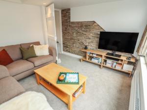 a living room with a couch and a flat screen tv at Rothay Cottage in Ambleside