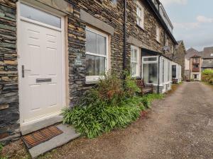 a white door on the side of a brick building at Rothay Cottage in Ambleside