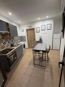 a kitchen with a table and chairs in a kitchen at Casetta Villabate in Villabate
