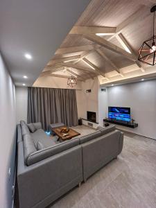 a living room with a large couch and a tv at Golden View Berat, 3BR Apartment with Castle View & Parking in Berat