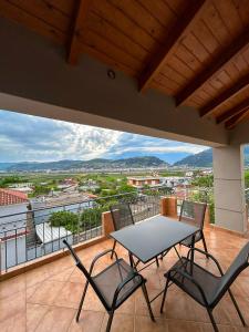 a table and chairs on a balcony with a view at Golden View Berat, 3BR Apartment with Castle View & Parking in Berat