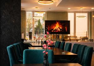 a restaurant with a table and chairs with a fireplace at Lillys Hotel München in Unterschleißheim