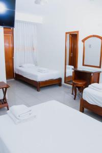a room with two beds and a mirror and a piano at Zentra San José Hotel & Cowork in Chiclayo +17 photos