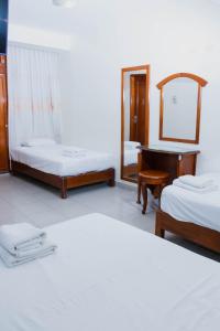 a bedroom with two beds and a mirror and a piano at Zentra San José Hotel & Cowork in Chiclayo