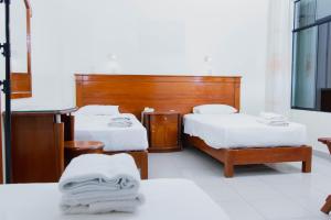 a hotel room with two beds with white sheets at Zentra San José Hotel & Cowork in Chiclayo