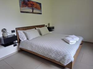 a bed with white sheets and pillows in a bedroom at The One Malpensa Rooms in Vizzola Ticino