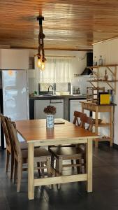 a kitchen with a wooden table and chairs in a kitchen at Longitude 31 House in Faja Grande