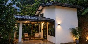 a white house with a patio with chairs and a table at Ella Nature viwe Lodge in Ella