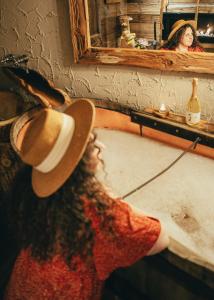 a woman wearing a cowboy hat in front of a mirror at URBAN PIC NIC in Piazza Brembana
