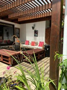 a patio with a couch and chairs on a deck at Casa Amparo in Frutillar