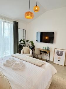 a bedroom with a white bed with a tv on the wall at Casa Katarina in Novalja