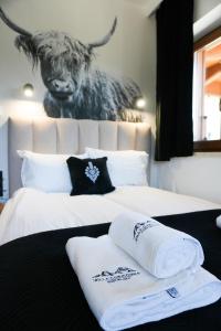 a bedroom with two beds with a picture of a bull at Willa Chrycówka - Jacuzzi, Basen, Sauna in Kościelisko