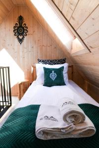 a bedroom with a bed with a green and white comforter at Willa Chrycówka - Jacuzzi, Basen, Sauna in Kościelisko