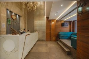 a man sitting at a reception desk in a hotel lobby at Hotel Heritage Street ! 100m from Golden Temple ! Parking & Restaurant in Amritsar