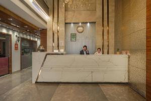 two people standing behind a counter in a lobby at Hotel Heritage Street ! 100m from Golden Temple ! Parking & Restaurant in Amritsar
