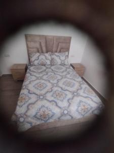 a bedroom with a large bed with a blue and white bedspread at Perla m'diq in M'diq