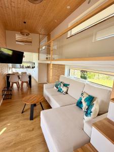 a living room with a white couch and a table at Tiny House Mountain View perfekt für Ruhesuchende in Köttmannsdorf