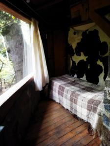 a small bedroom with a bed with a cow blanket at Hostal Nunatak in La Porteña